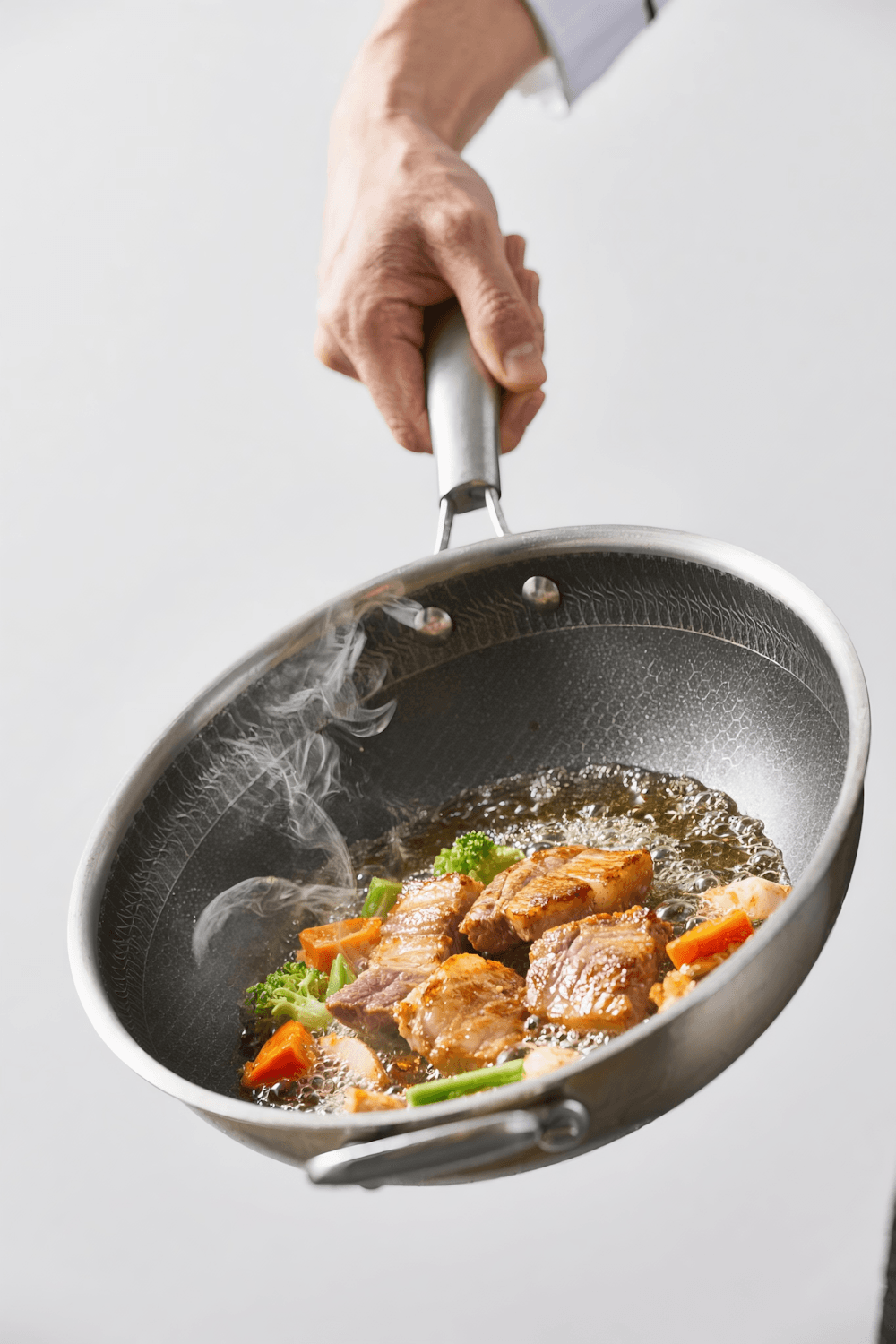 Seared pork and vegetables sizzling in a pan